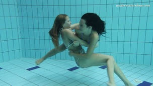 Two tempting mermaids caressing each other underwater