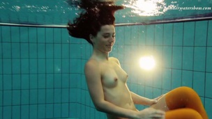 Slim brunette girl Nina Markova swimming naked in a pool